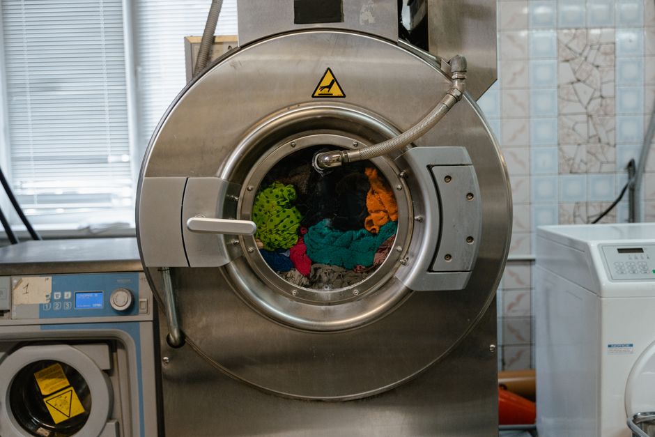 A close-up of an industrial washing machine operating in a laundry facility.